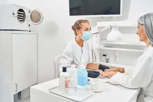 Cute young beautician doing sterile medical manicure