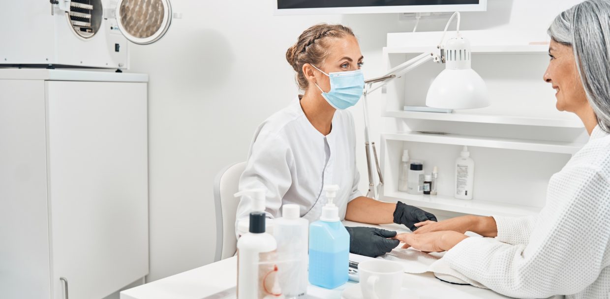 Cute young beautician doing sterile medical manicure